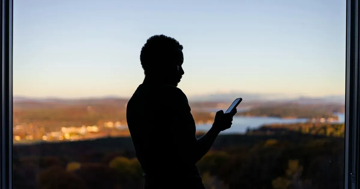 Smartfon skanujący kod QR na nagrobku — cyfrowy memoriał ze zdjęciami i wspomnieniami